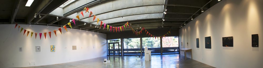 panorama of gallery with string of flags on ceiling, sculptures on floor, paintings and drawings on walls
