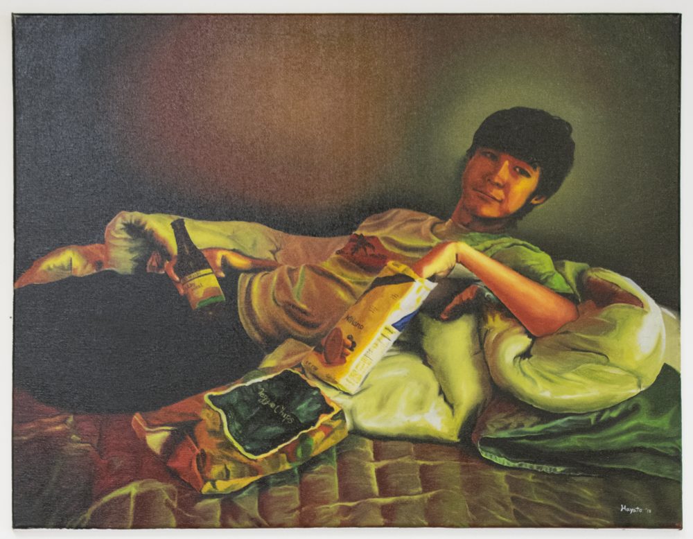 Oil painting of a young man reclining on blankets on a bed. He looks is looking towards the viewer, holding a bottled drink in one hand, while the other hand is reaching into a bag of cookies.