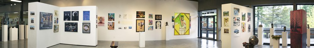 Panorama installation view of gallery with several artworks on the far wall in the background, on walls on the left and right, and on pedestals throughout the room. To the left is a freestanding artwork with windows behind it.
