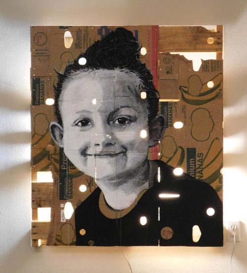 portrait of a child on a cardboard box with light shining through it.