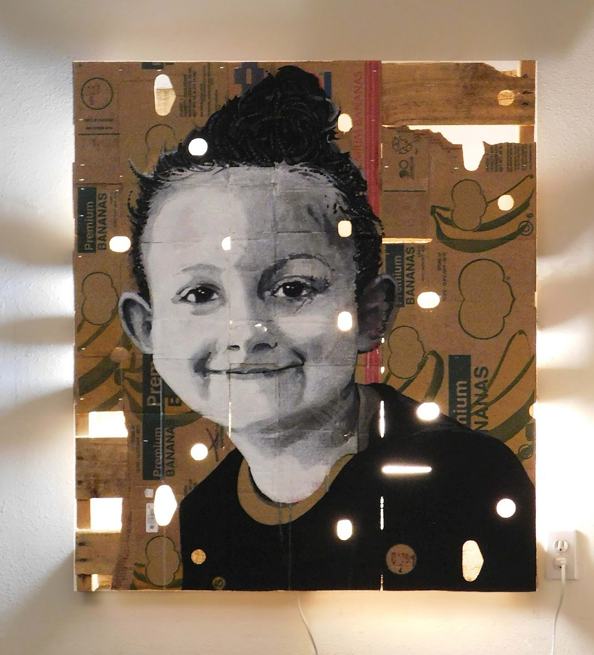 portrait of a child on a cardboard box with light shining through it. 