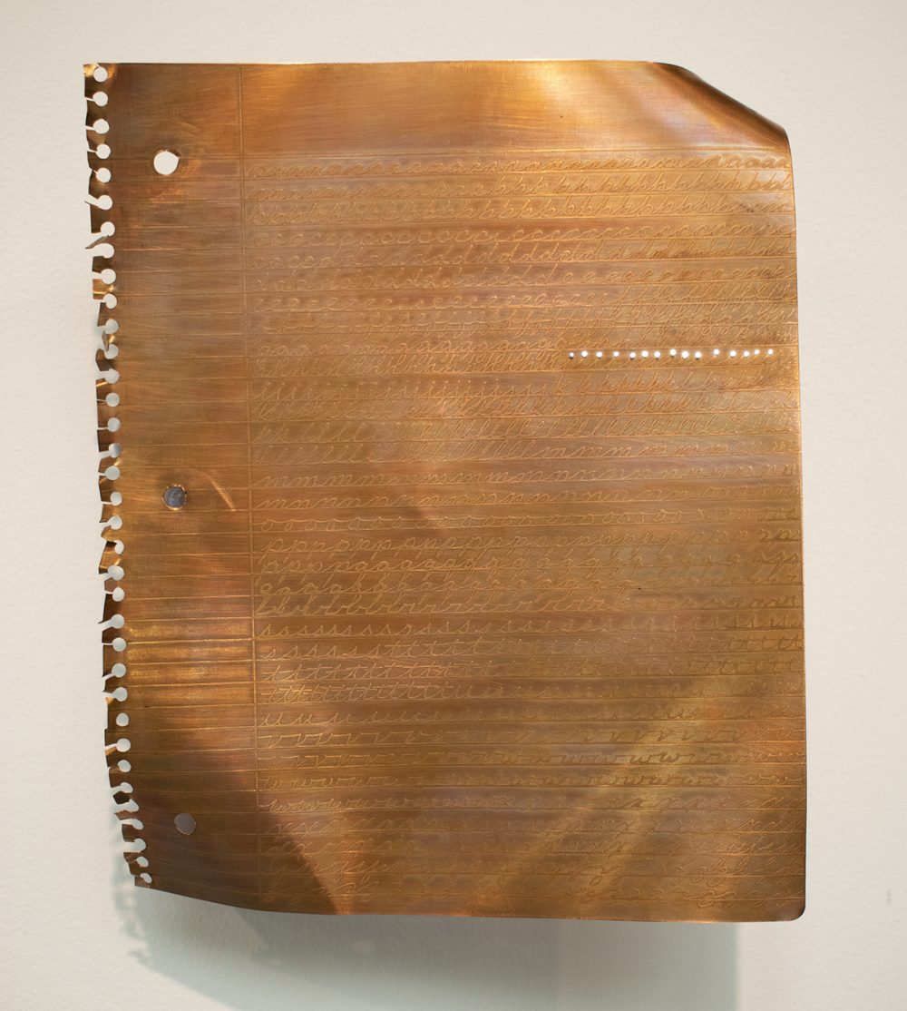 A sheet of copper is cut out to look like a sheet of paper torn from a spiral bound notebook. Etched into the copper is the alphabet, depicted as if it is a child's exercise in cursive handwriting.The sheet is bent and installed vertically on a white gallery wall. On the upper right of the sheet are a series of small holes that have white light emanating from them.