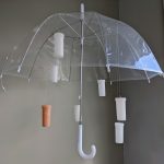 Katherine Wood, Rainy Day RX, 2020cast wax (pill bottles), found objects (umbrella, vegetable cellulose capsules), plastic cord, 36" x 30"