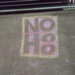 A photograph of a chalk message on a sidewalk.