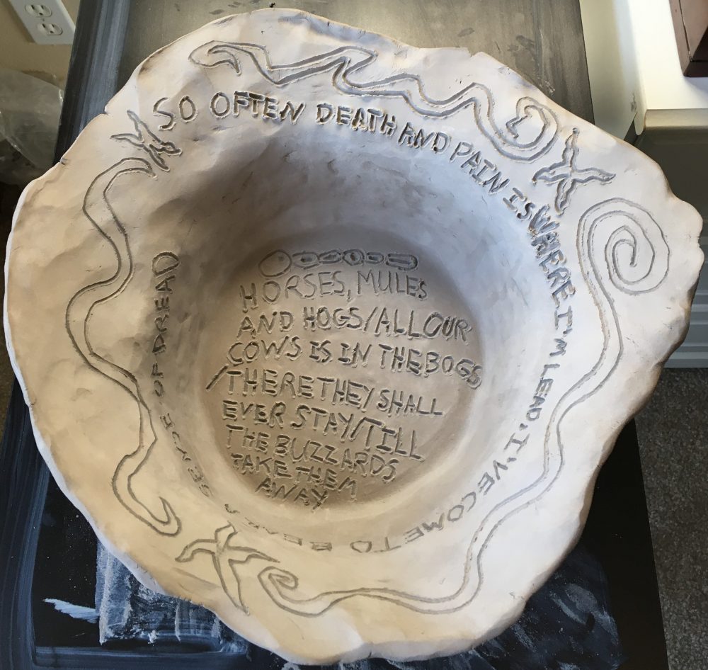 A simple clay vessel with poems and imagery expressing darker concepts.