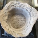 A simple clay vessel with poems and imagery expressing darker concepts.