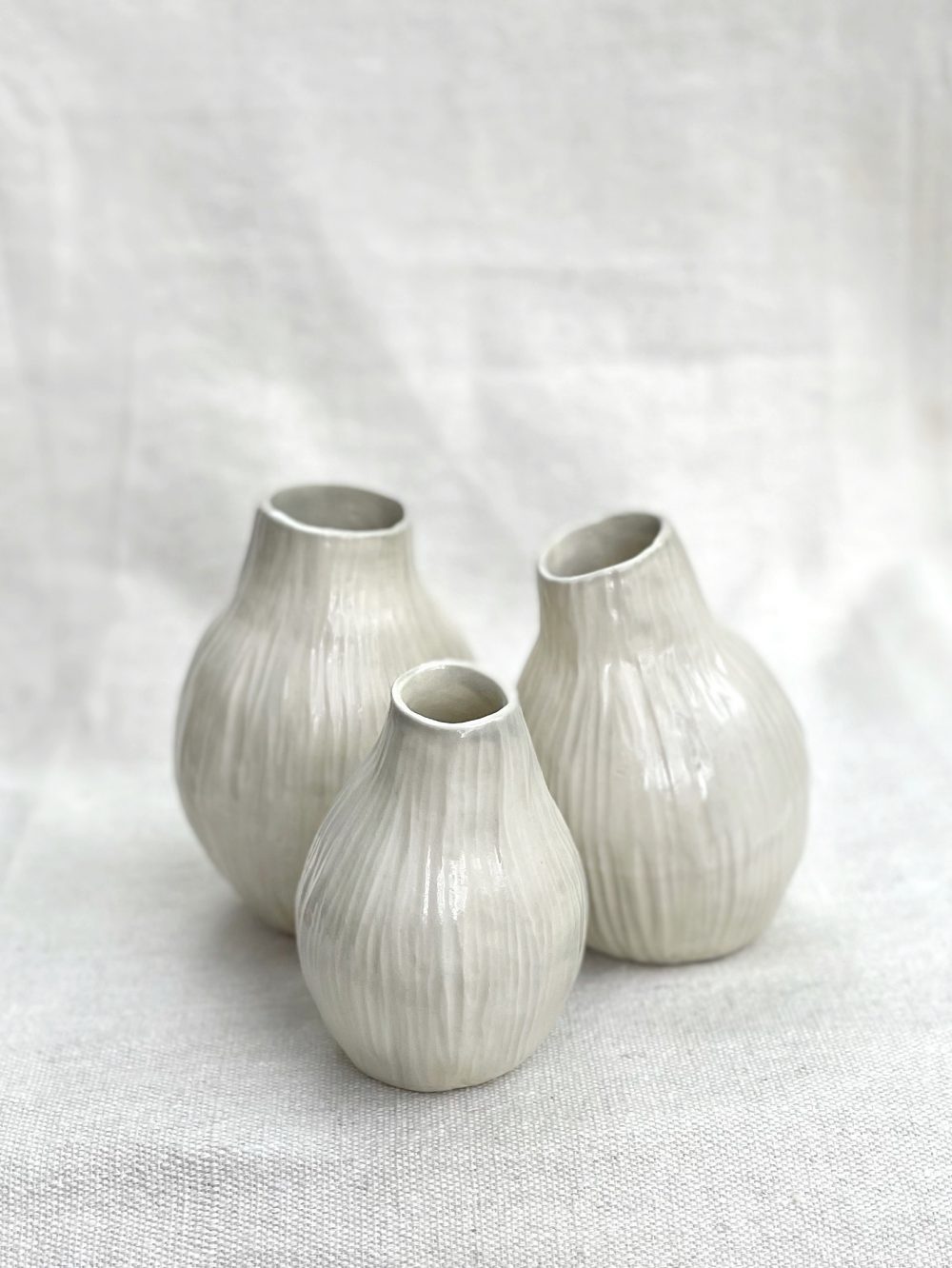 Cluster of three white vases reminiscent of eucalyptus seed pods.