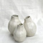 Cluster of three white vases reminiscent of eucalyptus seed pods.