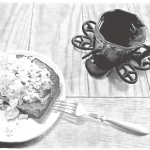 A black and white drawing of a plate of eggs on toast with a dark mug full of tea. A metallic fork rests partially on the edge of the plate and angles downward to touch the wood-grain table.