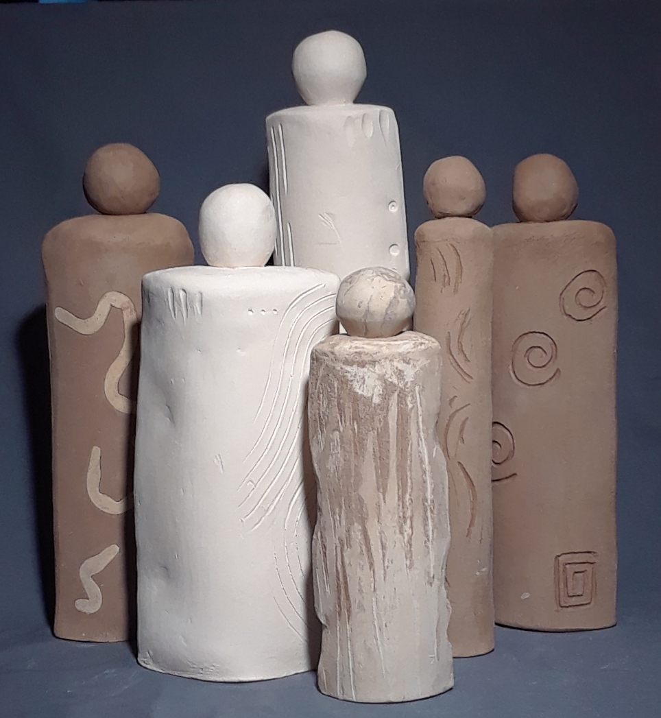 Slab work in clay of 6 people figures of different sizes and shapes being photographed together to form a group.