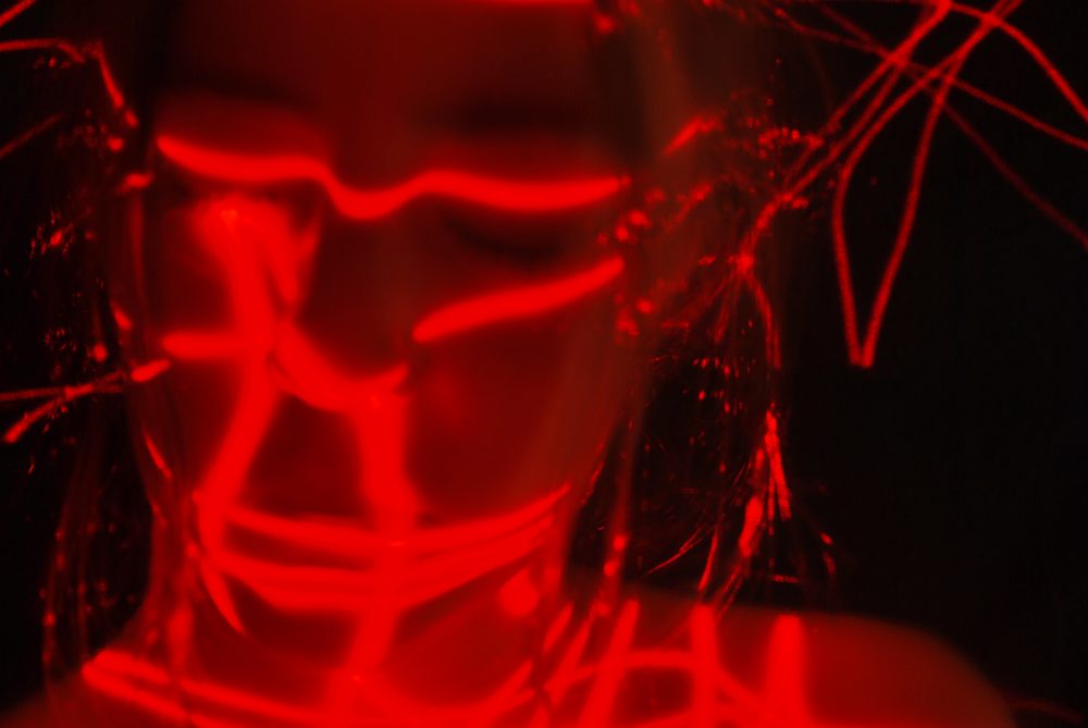 A girls face with red lines zig zagging accross her face