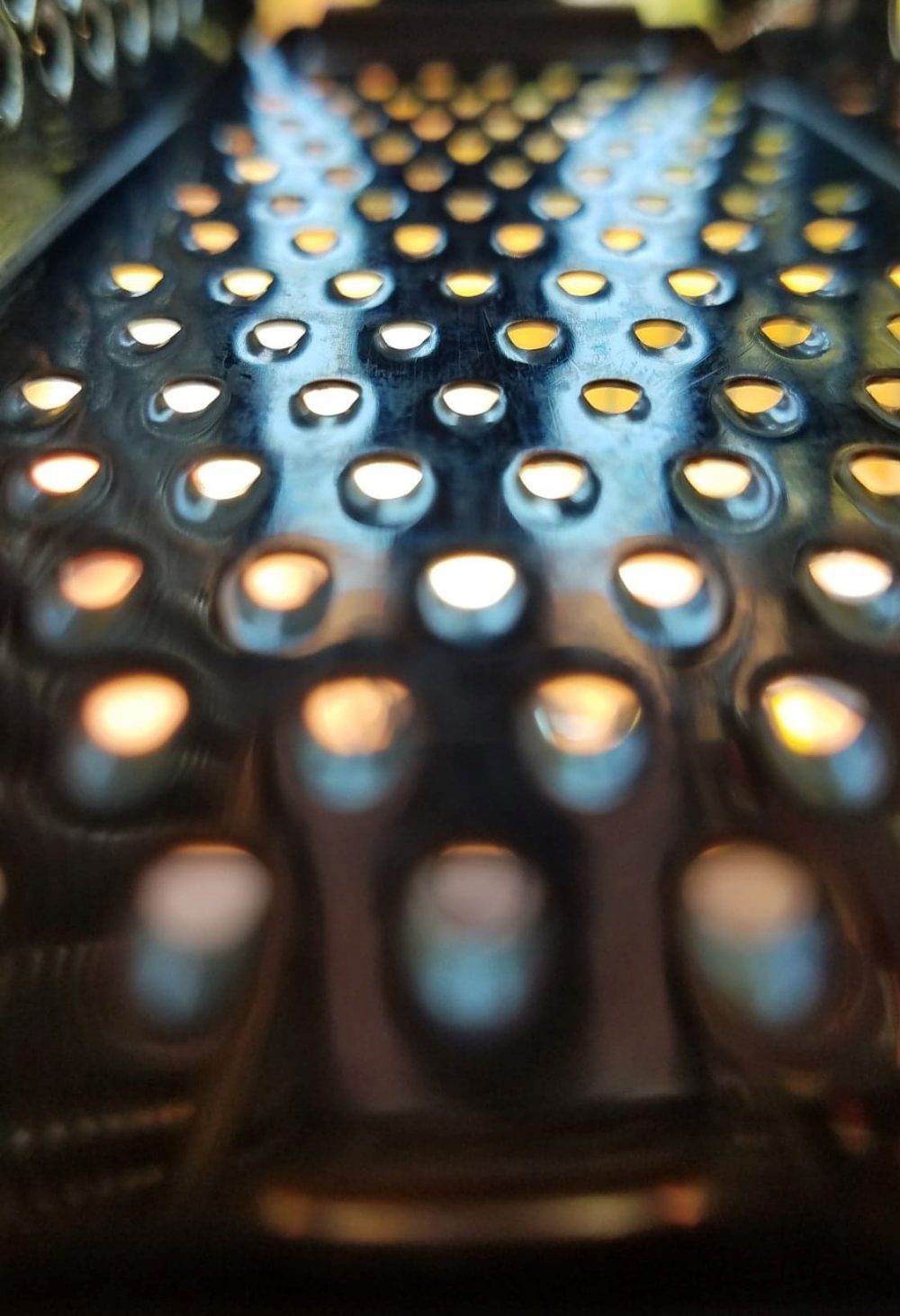 A macro photo of a zester with light coming through the holes.