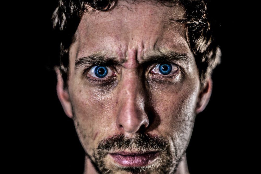 An up-close photograph of a man who is experiencing both anger and loss.