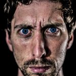 An up-close photograph of a man who is experiencing both anger and loss.