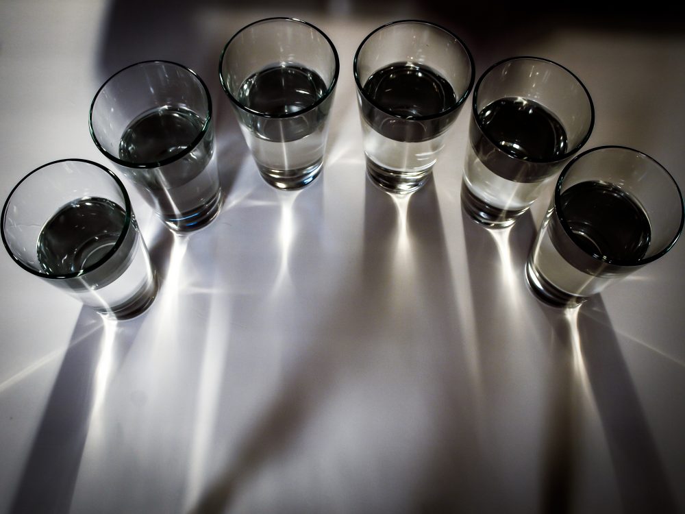 Aerial view of a half circular row of small glasses with water in them.