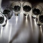 Aerial view of a half circular row of small glasses with water in them.
