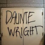 Photograph of the name "Daunte Wright" written all-caps in black spray paint over the exit doors of a building in downtown Portland.
