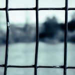 Frame within a frame of a gate with a lake in the background