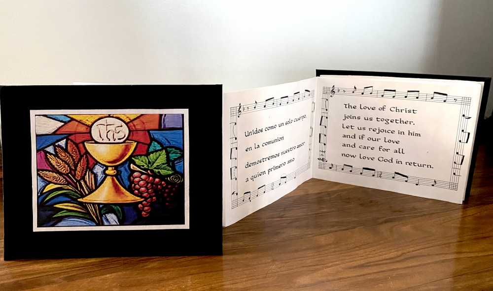 A calligraphy accordion book with a church image on the front.