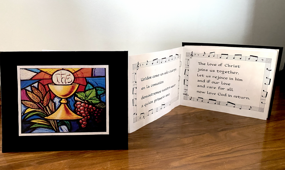 A calligraphy accordion book with a church image on the front.