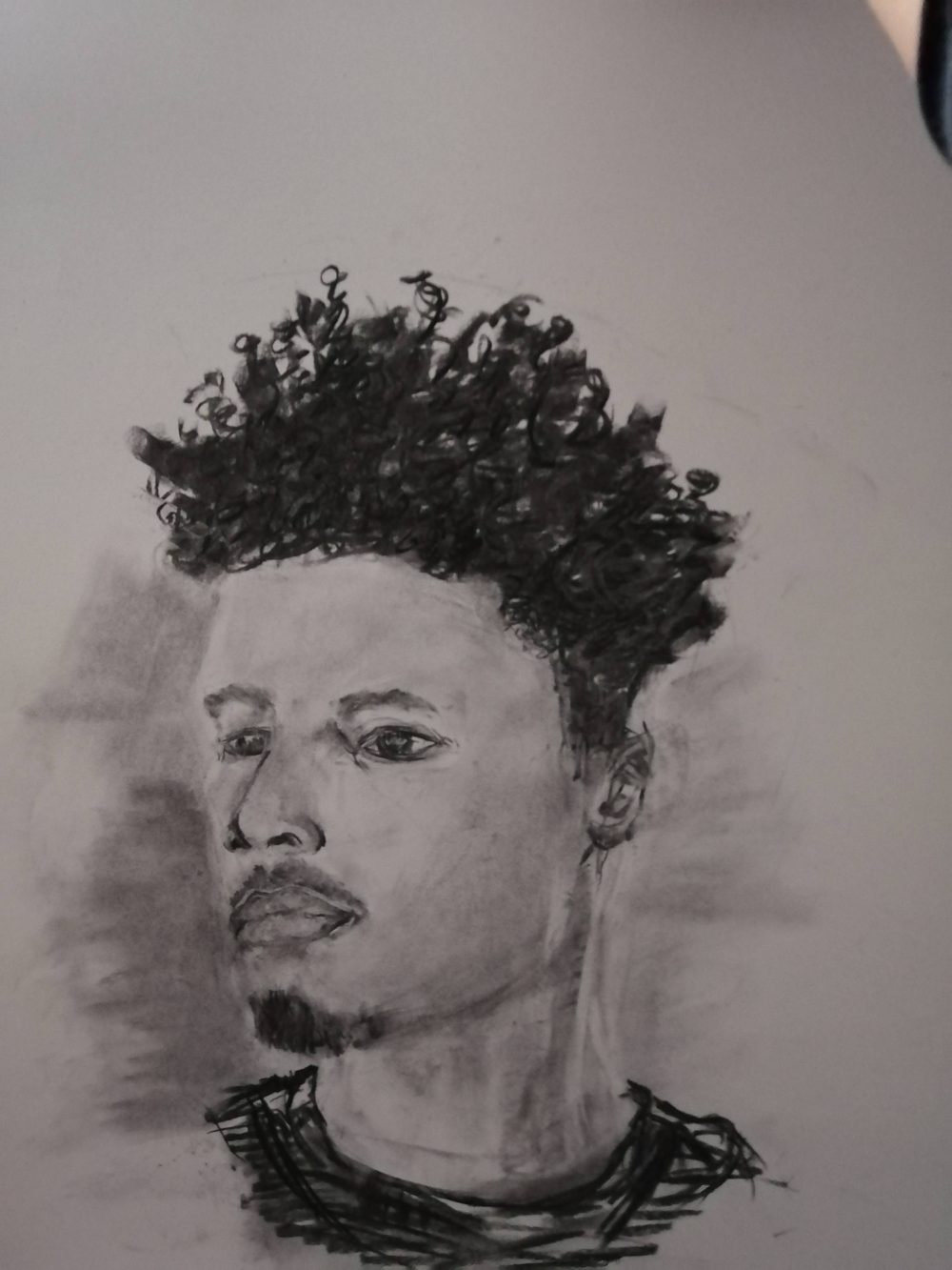 A black and white charcoal drawing depicting a younger black man.