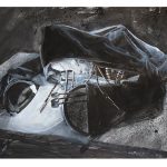 A black and white painting of a hooded figure slumped over a table. It has a white, statuesque face illuminated by its lamp-like right hand. Cables spill out from beneath its cloak.