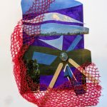 A collage with paper, netting, stone, and sticks.