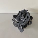 A sculpture with an array of black flowers.