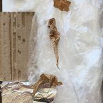 Image of cardboard with crumpled plastic wrap and tinfoil.