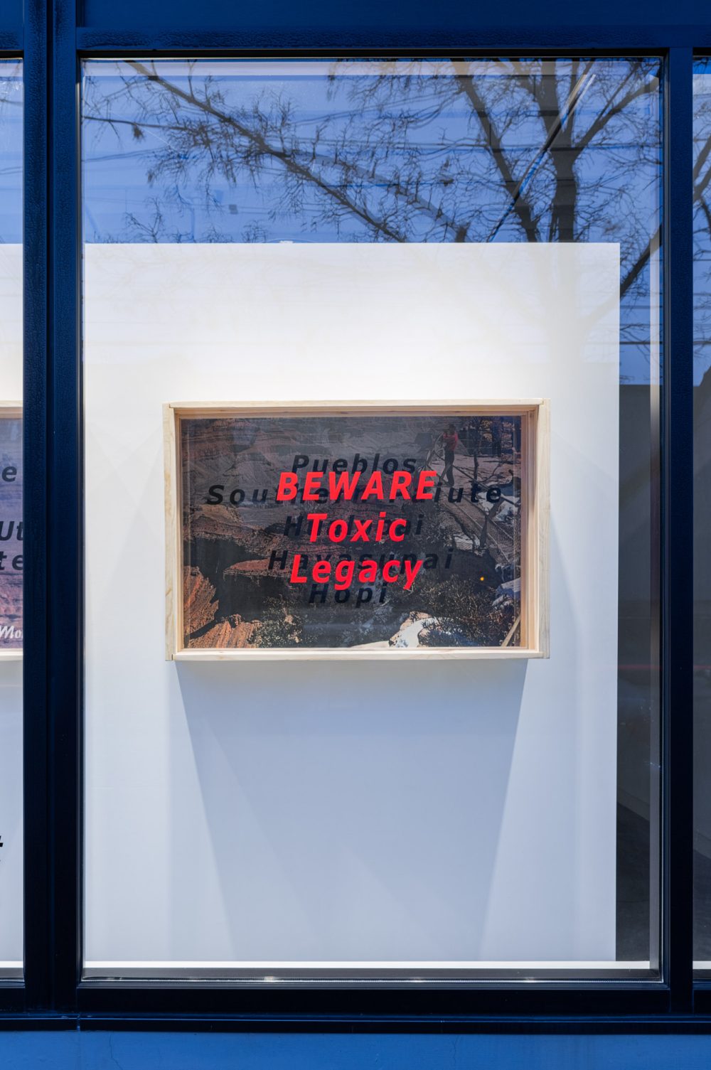 Large diorama box hanging on a wall in a window.