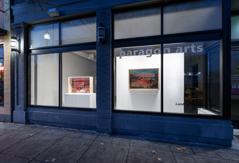 Two diorama boxes in a window.