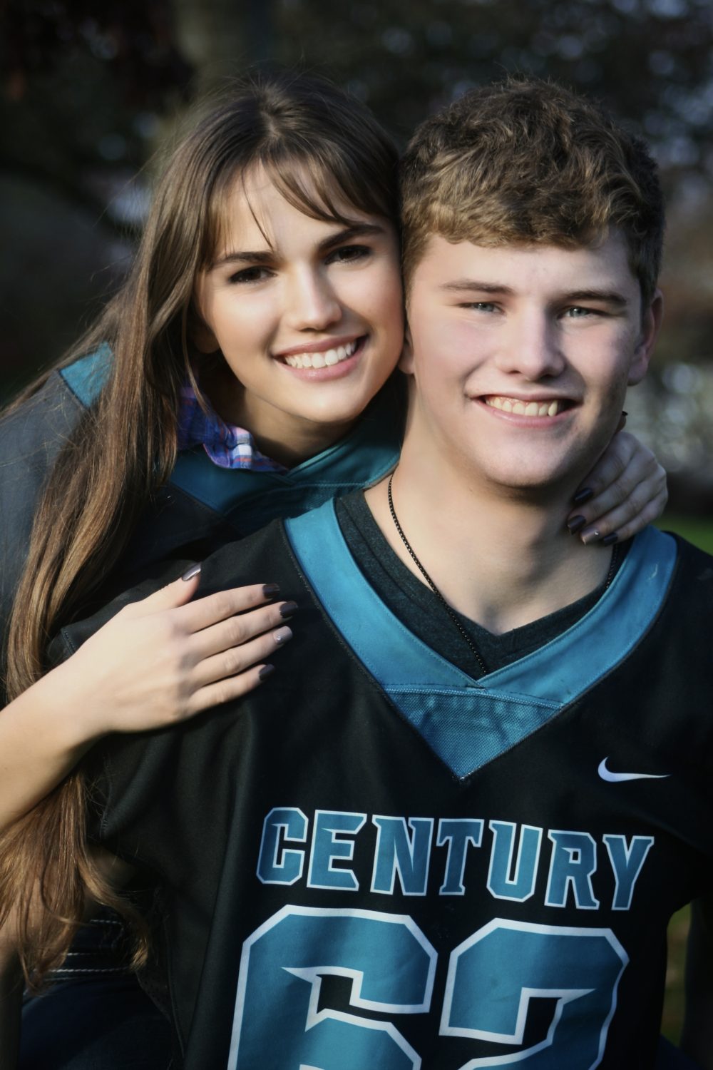 A photograph of a young couple, which includes my friend and his girlfriend in football jerseys to represent my friends number on the team. And the special bond and overall joy they have.