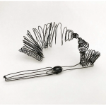 A black wire sculpture of a toothpaste tube and toothbrush which are connected together by toothpaste.