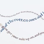 This is a piece of paper with song lyrics written in calligraphy in three sizes, all intersecting and written on curves, like hills, in blue gray and ochre colored inks.