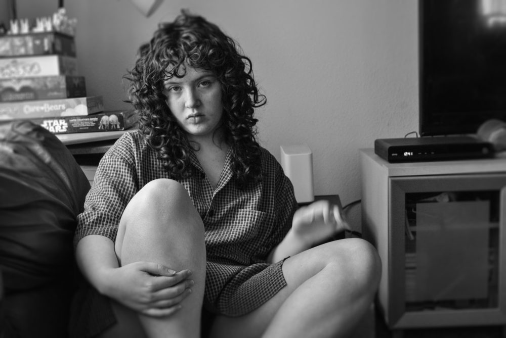 The photograph features myself sitting on a couch, with my livingroom being seen slightly in the background. The photo is in black and white.