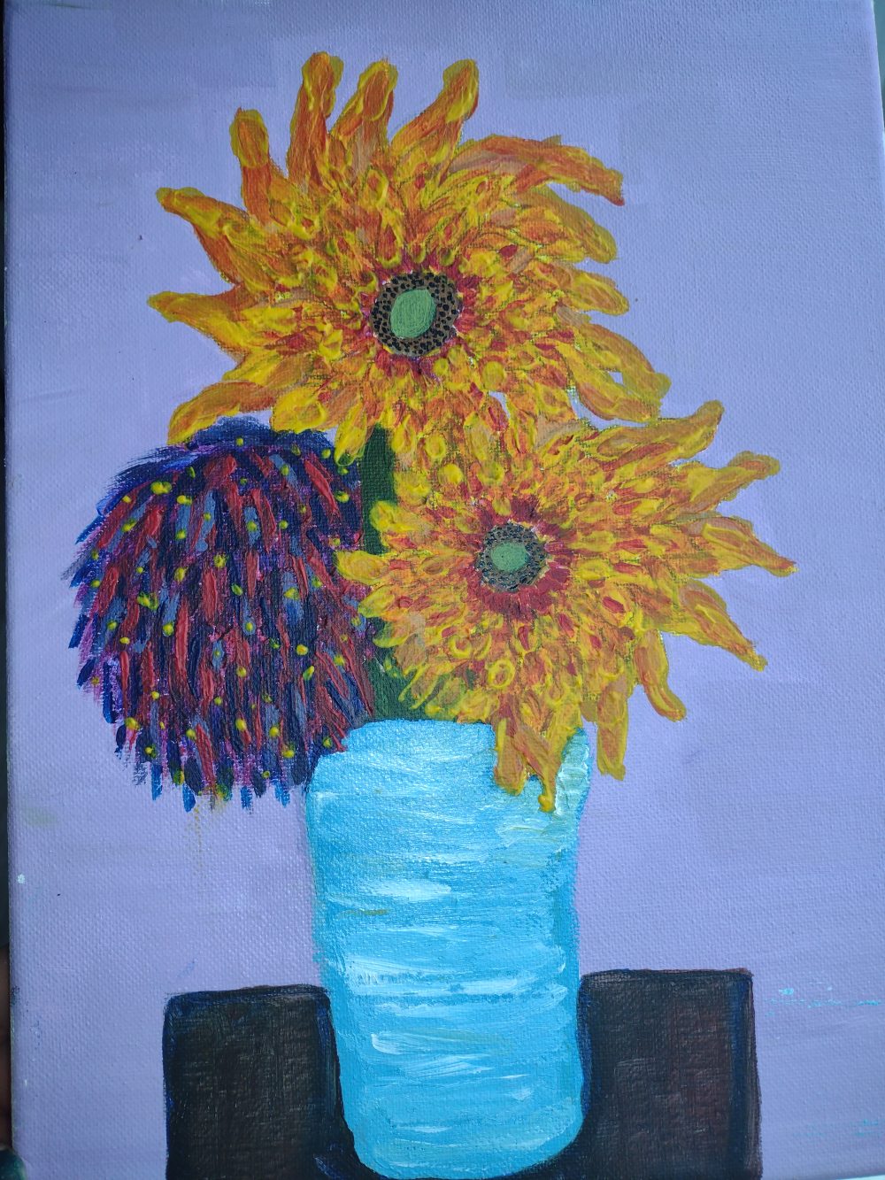 There is a lovely set of sun flowers displaying vibrant colors, sitting on a small drawer.
