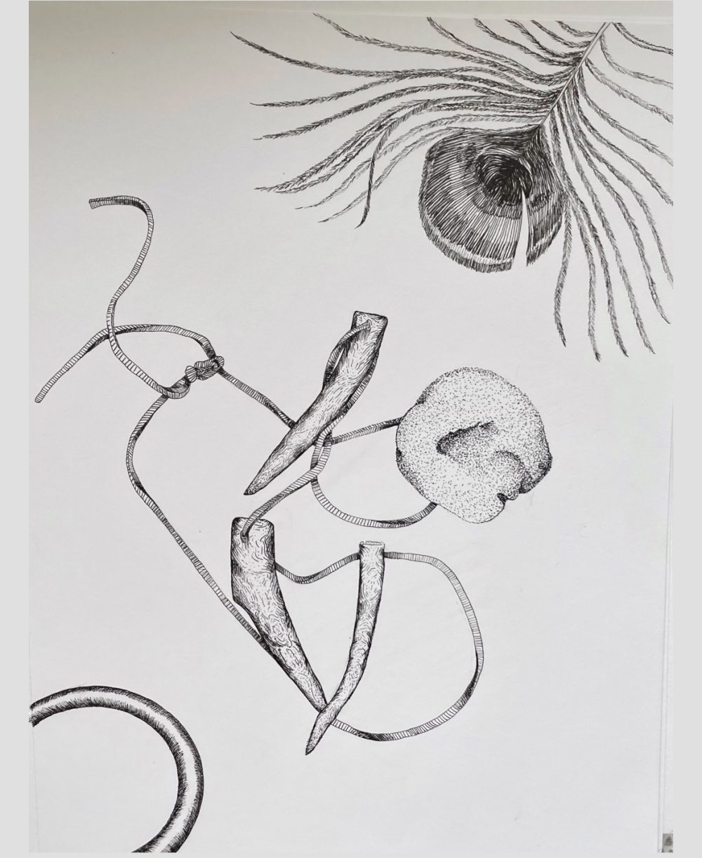 3 pieces of antler on a necklace tangled up in the middle of the page. A rock rests upon the leather piece tying the antlers together. A peacock feather comes down from the upper right corner. A wooden bracelet comes up from the lower left hand corner.