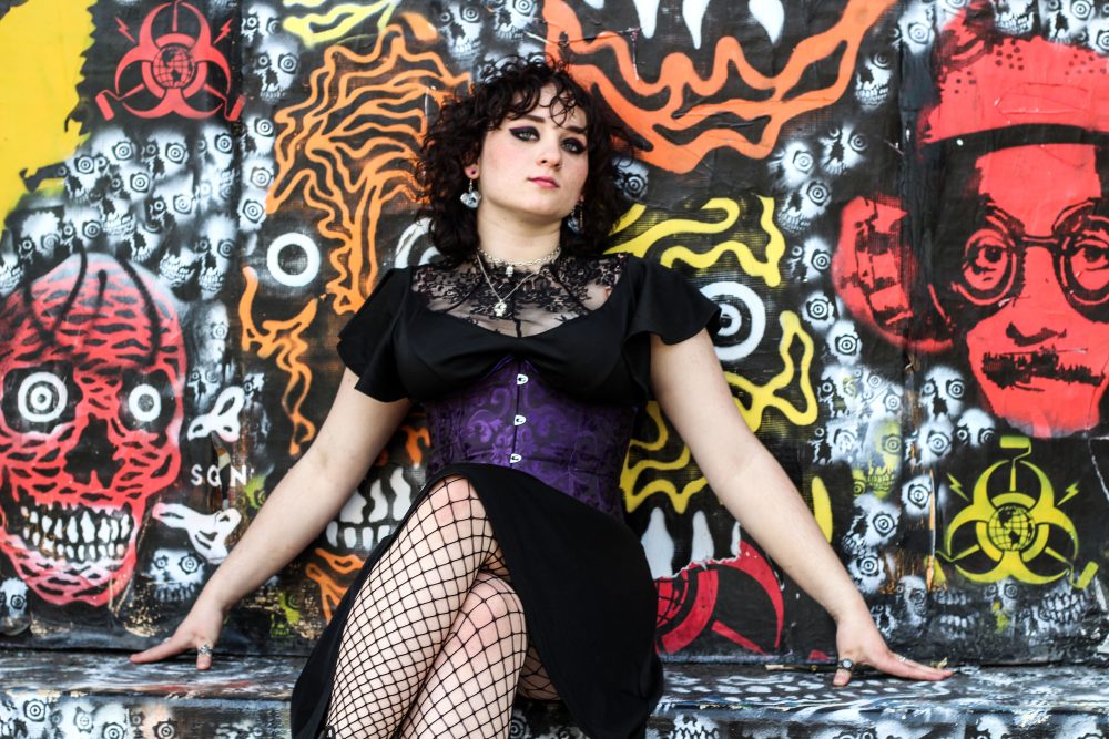 Portrait of an alternative teenager with graffiti art in the background.