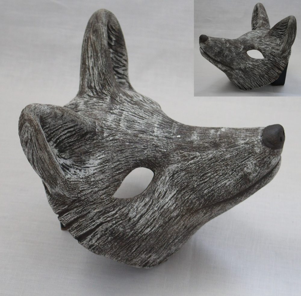 A brown and white mask that is the shape of a fox's face.