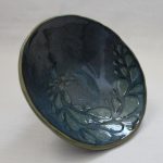 A bowl with a pattern of blue teardrops swirling out from the middle.