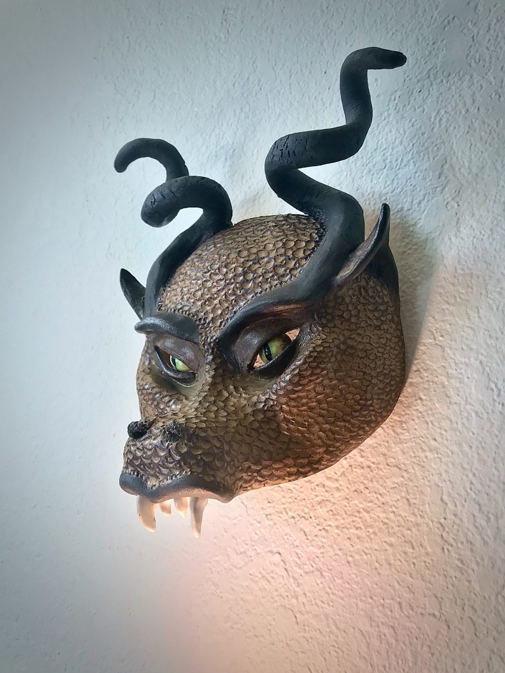 An angled view of a half-face mask that looks like a dragon with horns.