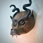 An angled view of a half-face mask that looks like a dragon with horns.