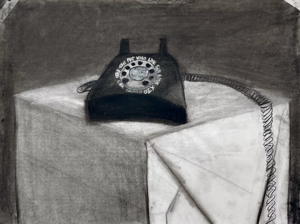 A dark black phone resting on top of a white box with a gray back ground.