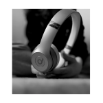 Photograph is in B&W, person is holding headphones towards the viewer.