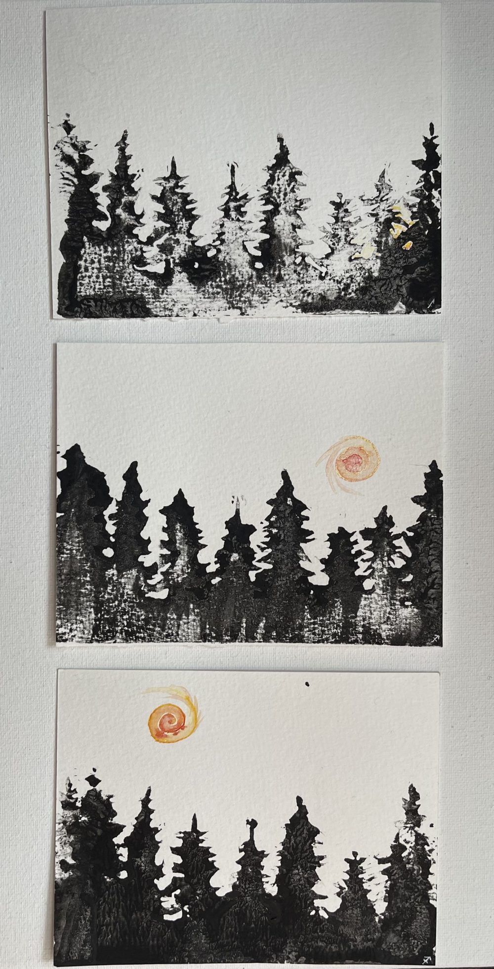 Ink block prints of trees, with sun peeking through them, rising.