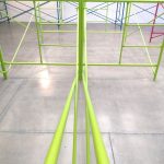 Green, teal and pink scaffolding in a gallery space.
