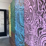 Large-scale black line drawings on colorful paper hanging on the gallery walls.