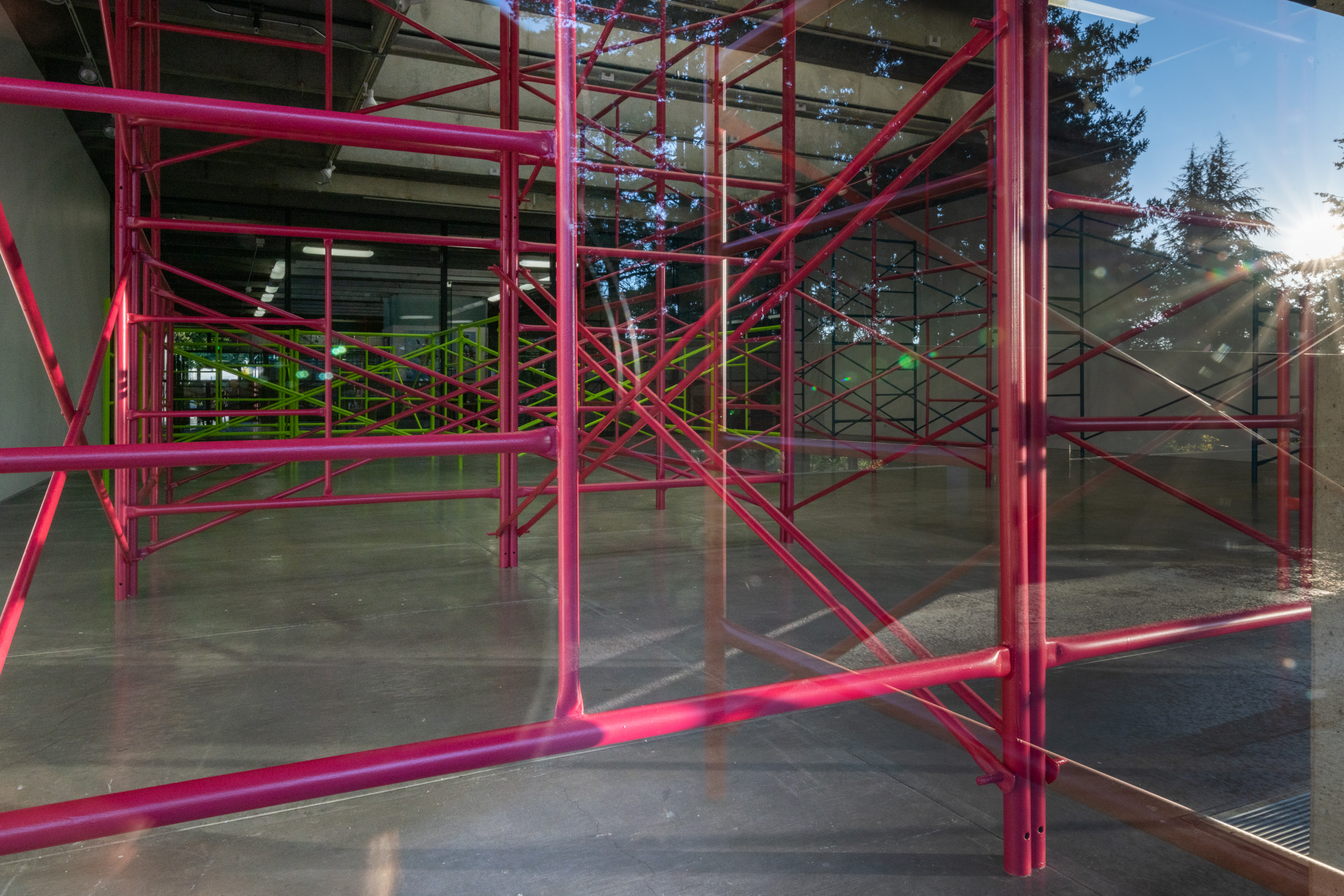 View into the gallery with pink and green scaffolding.