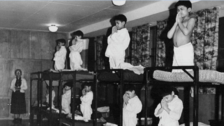 Photograph of young Indigenous boys praying in a boarding school.
