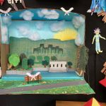 Detail of collage of landscape, city scape, and interior scenes, two-dimensional and three dimensional, installed on a black wall.